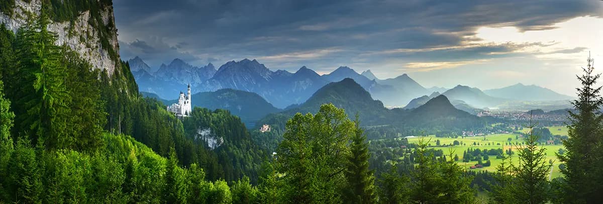 Schloss Neuschwanstein eingebettet in die Bayerischen Alpen mit dramatischen Berggipfeln im Hintergrund